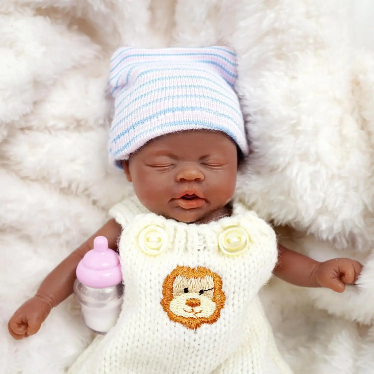 Kai asleep in his lion overalls and striped knit cap