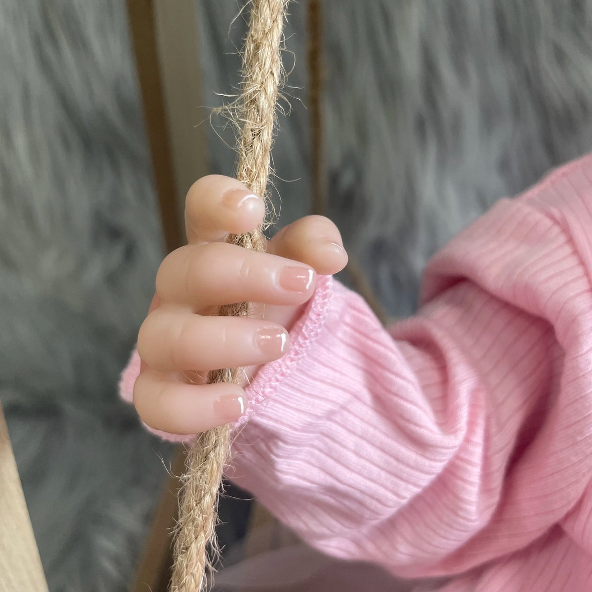 Close-up of Aria's hand gripping a rope