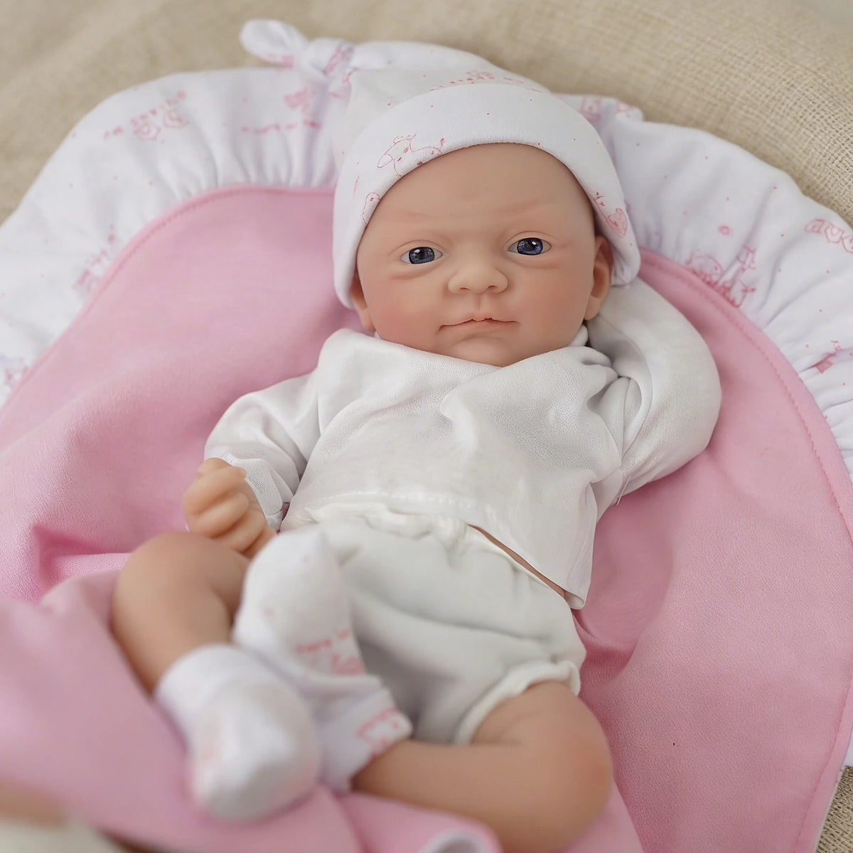Ivy girl micro preemie in a white knit hat and bodysuit on a pink blanket