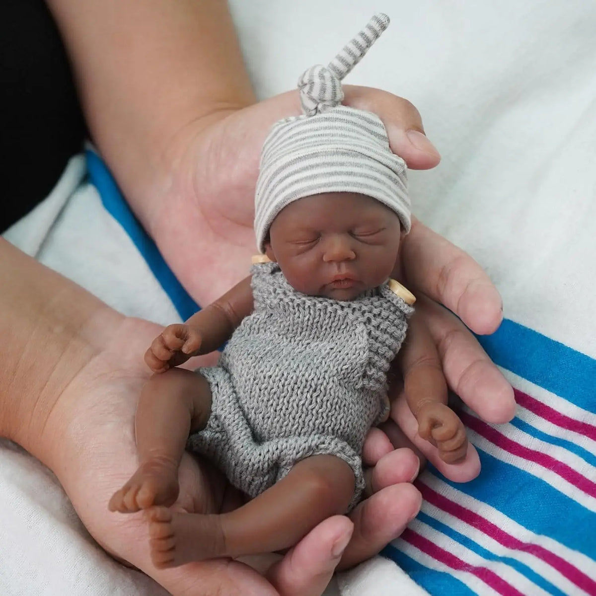 Miles held in an adult's hands, showing his 7 inch size